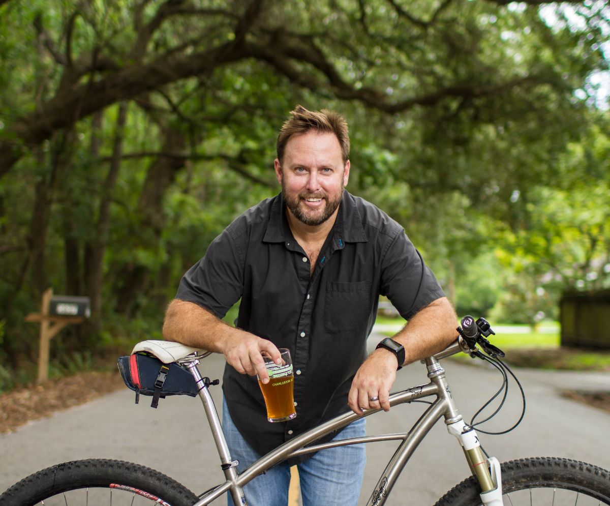 brewery owner holding beer with bike