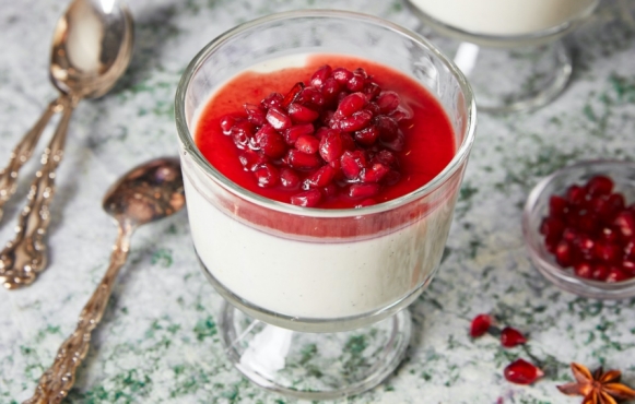 cup of panna cotta topped with pomegranate syrup