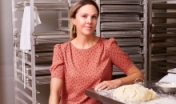 Baker sitting near table with dough