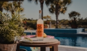 a bottle of liquor sitting near the pool